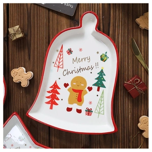 Detail of bell-shaped ceramic Christmas plate with gingerbread man and festive holiday motifs