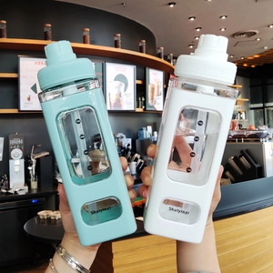 Close-up of square plastic sports bottles with silicone sleeves and measurement scales