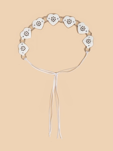 Close-up of white heart leather chain with star cutouts and metal rings detail