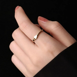 Minimalist gold titanium steel ring with an irregular polished surface worn on index finger