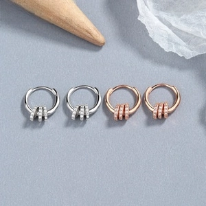 Detailed macro view of 925 sterling silver hoop earrings with zircon rings in silver and rose gold