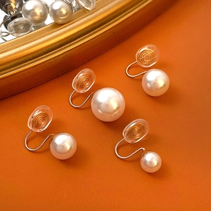 Detail view of four pearl clip-on earrings with invisible golden coil backings