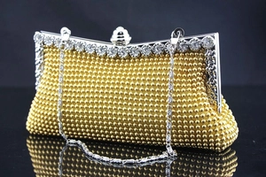 Nahaufnahme der gewebten goldenen Abendtasche mit strassbesetztem Silbermetallrahmen