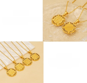 Close-up of golden stainless steel round initial necklace with hollowed edge details