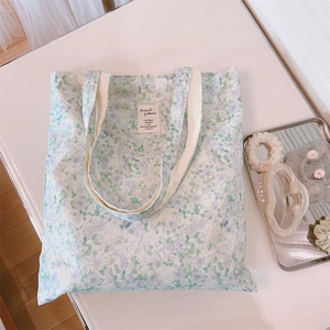 Close-up of floral canvas tote bag with elegant blue-green pattern and cotton strap