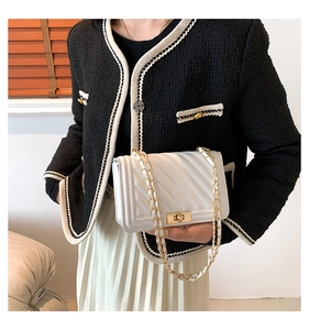 Detail of white V-quilted leather crossbody bag with gold-tone metal turn-lock closure