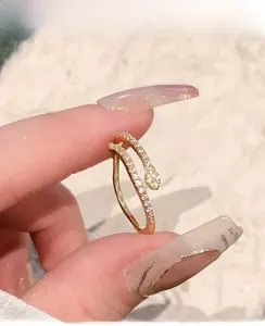 Detail of gold snake-shaped open ring featuring sparkling white zircon micro-pave
