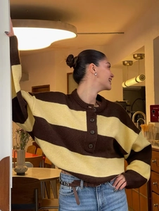 Detalle de jersey de punto a rayas marrones y beige con cuello henley y tres botones