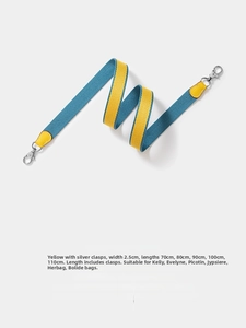 Detail of yellow and teal canvas shoulder strap with silver metal hooks and leather trim