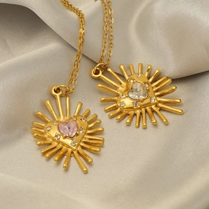 Gros plan de pendentifs cœur en forme de soleil avec zircons sur soie dorée