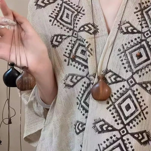 Detail of bohemian wood bottle pendant necklace on linen ethnic clothing