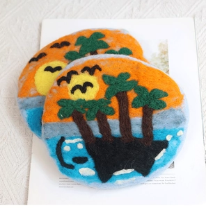 Detail of handmade tropical sunset wool felt coasters with palm trees on magazine