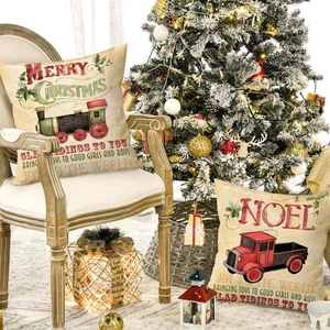 Christmas cushion covers with vintage red truck and train prints on a beige sofa pillow