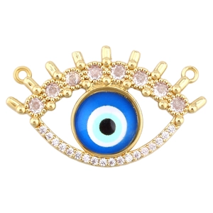 Macro detail of gold-plated evil eye connector with blue glass and cubic zirconia