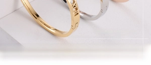 Close-up of gold and silver geometric hollow titanium bracelets with Roman numerals