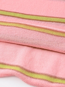 Macro detail of soft pink striped knit fabric with green and brown decorative textures