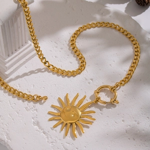 Vintage sun face pendant necklace in gold finish on white textured stone surface
