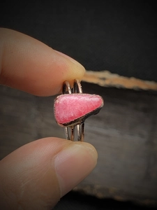 Macro shot of retro silver ring featuring a raw pink gemstone with antique finish