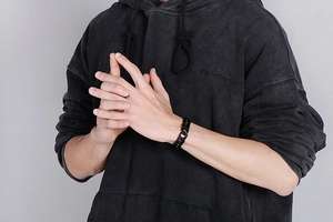 Gros plan d'un bracelet gourmette noir mat porté au poignet pour un style urbain chic