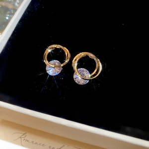 Macro shot of interlocking golden circle earrings with sparkling round cubic zirconia