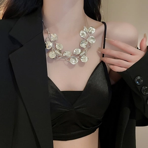 Detail of silver leaf necklace on model neck showing intricate metallic leaf craftsmanship