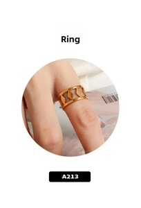 Close-up of a wide gold-plated cutout geometric ring worn on a person finger