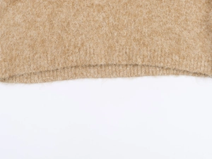 Dettaglio della polo in maglia kaki che mostra la consistenza del mohair e le cuciture