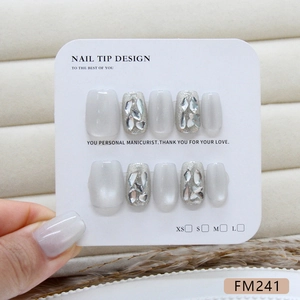 Sparkly cat-eye press-on nails set with silver glitter and rhinestones on display card