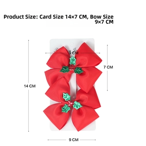 Detail showing two red Christmas bow hair clips with holly leaf on display card