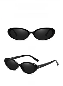Detail of vintage oval black sunglasses with gray lenses and metallic temple accents
