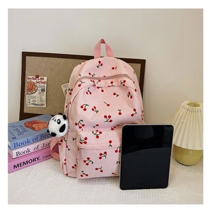 Close-up of pink corduroy cherry backpack featuring a cute panda plush keychain detail
