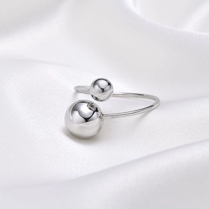 Minimalist adjustable stainless steel bead ring in silver finish on white silk background