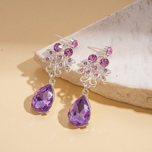 Detail of silver waterdrop earrings with purple crystals and small zircon stones