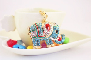 Vue détaillée d'un porte-clés éléphant doré avec strass bleus et émail coloré décoratif