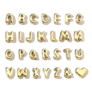 Macro shot of gold alphabet beads from A to Z with heart and ampersand symbols
