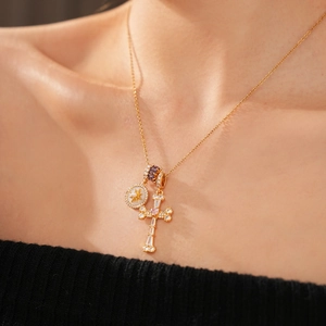 Detail of 18k gold plated necklace with zircon cross and mother of pearl star charms
