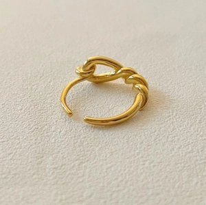 Close-up of golden 925 sterling silver knotted ring with adjustable open design band
