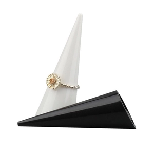 Close-up of a silver daisy flower ring displayed on a white conical jewelry stand