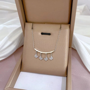 Minimalist titanium steel necklace with four shiny gold butterfly charms in a box