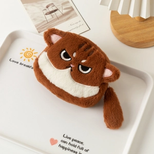 Detail of plush cat coin purse with embroidered expression on a cozy white tray