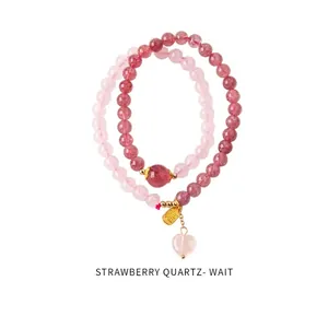 Detail of strawberry quartz beads with gold Fu charm and pink heart pendant