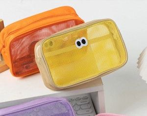 Close-up of colorful mesh storage bags with cute eye embroidery and zipper closures
