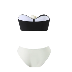 Flat lay detail of black and white bandeau bikini top with matching white swim bottoms