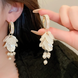 Detail of floral earring with golden crystal stud, white petals, and pearl tassel