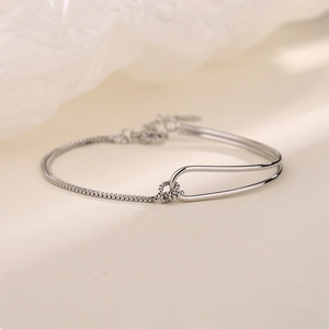 Detail view of minimalist silver chain bracelet with polished arc bar and lobster clasp