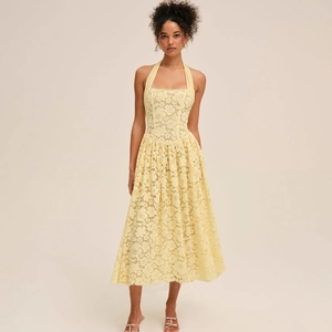 Détail d'une robe midi en dentelle jaune avec licou, taille cintrée et jupe en ligne A
