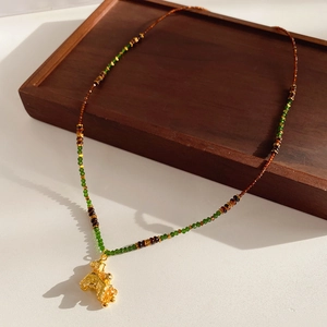Macro view of vintage gold dragon pendant necklace with tiger eye beads on wooden tray
