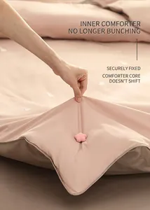 Close-up of pink star-shaped duvet clip securing a quilt to prevent shifting and bunching