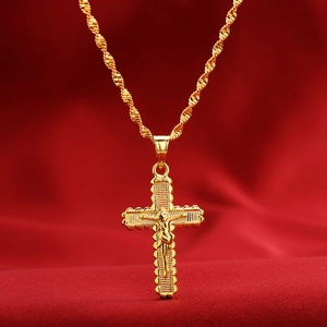 Detailed close-up of a gold-plated crucifix pendant on a rope chain over red velvet