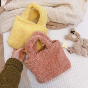 Gros plan de sacs à main en polaire teddy jaune et rose aux détails doux